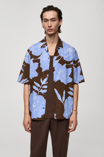 Bruin bloemenshirt met korte mouwen van MANGO, met blauwe bloemmotieven, gecombineerd met bruine tanktop en pantalon.