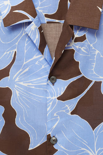Bruin bloemenhemd van MANGO, met korte mouwen en een opvallend bloemmotief in blauw en wit.
