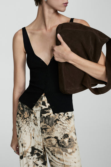 Beige broek van MANGO, met een abstract slangenhuidpatroon en gecombineerd met een zwart hemd met knoopsluiting.