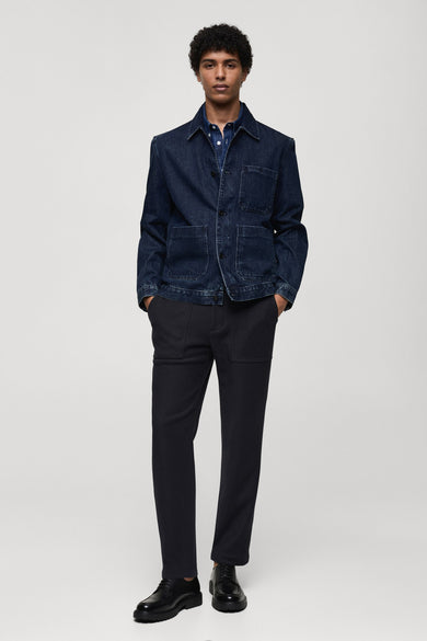 Jeansjas van midblauw denim van MANGO, met opgestikte zakken en gedragen over een blauw overhemd.