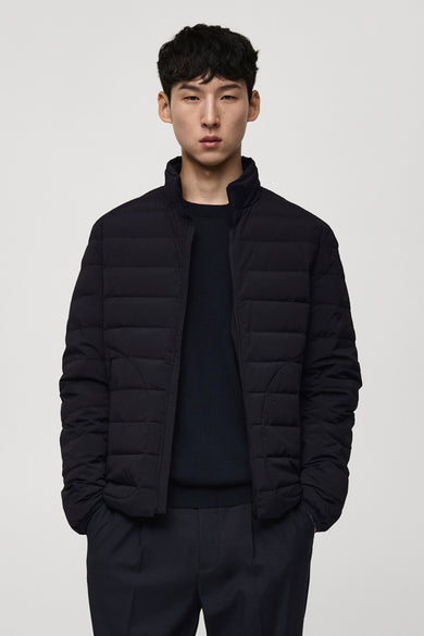 Korte blauwe jas van MANGO, gedragen over een donkerblauwe trui en pantalon.
