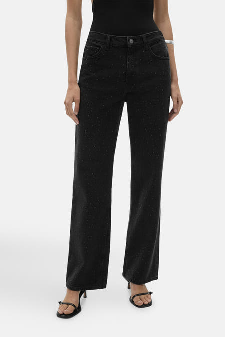 Donkergrijze rechte jeans van MANGO, met subtiele zilveren spikkels en gecombineerd met zwarte sandalen.
