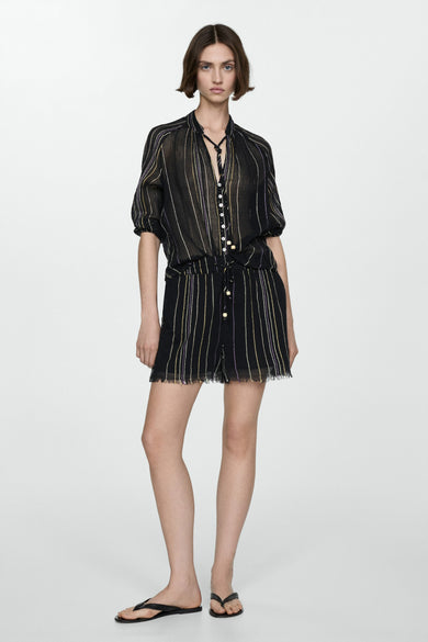 Zwarte short van MANGO, met verticale strepen en een gerafelde zoom, gedragen met een gestreepte blouse en teenslippers.