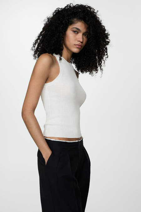 Beige singlet van MANGO, gecombineerd met een zwarte pantalon, close-up.