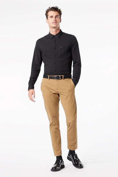 Beige chino van DOCKERS, gedragen met een zwart overhemd en zwarte leren schoenen.
