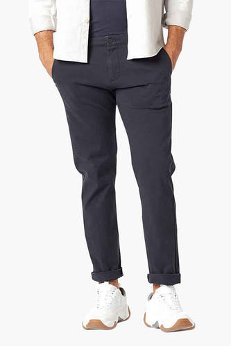 Blauwe chino van DOCKERS, met opgerolde pijpen en witte sneakers.
