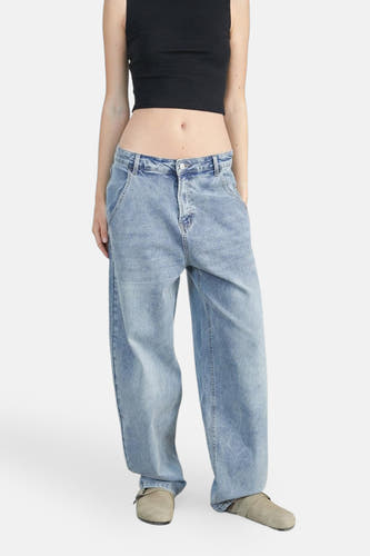 Jean décontracté en denim bleu moyen parmi 24 couleurs, porté avec un crop top noir et des sandales kaki.