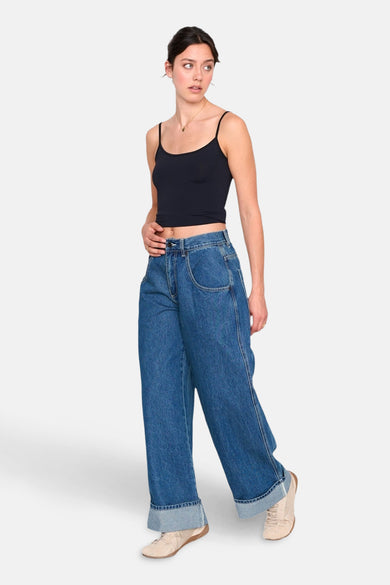 Jean décontracté en denim bleu moyen de 24 Colours GMBH, avec des poches de pantalon rabattues et associé à une chemise noire.