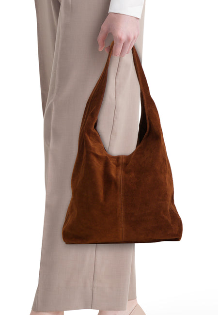 Bruine suède hobo schoudertas van Access® met decoratieve stiksels, gedragen bij een beige broek.