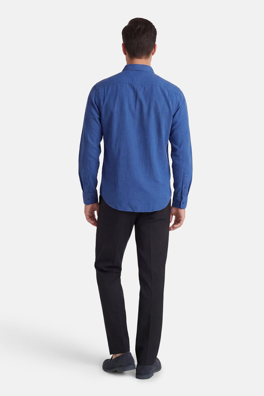 Blauw hemd met lange mouwen van Levi's®, effen ontwerp, gecombineerd met zwarte pantalon en suède loafers, achteraanzicht.
