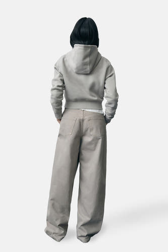 Pantalon beige de MANGO, avec des jambes larges et des poches arrière, vu de derrière.