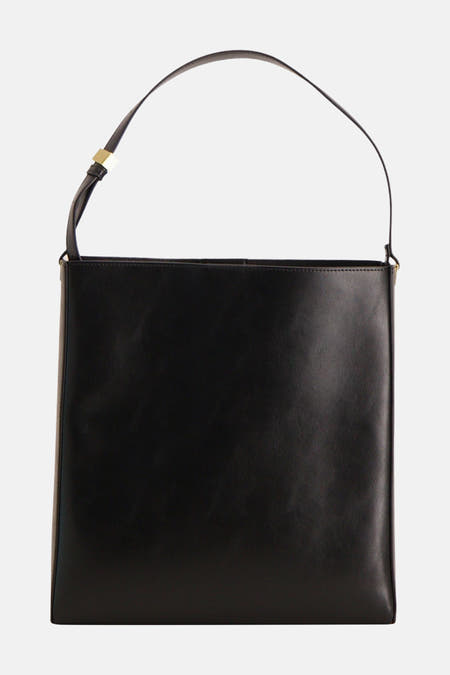Zwarte tas van MANGO, met een smalle schouderband en gouden details.