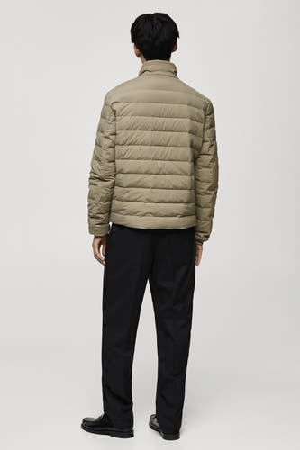 Manteau court gris de MANGO, vu de derrière, combiné avec un pantalon noir et des chaussures noires.
