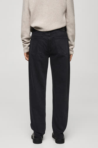 Jean droit en denim gris foncé de MANGO, vu de l'arrière avec un pull beige et des chaussures noires.