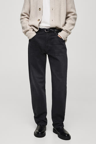 Jean denim bleu marine foncé de MANGO, avec une ceinture noire, associé à un cardigan beige et des chaussures noires.