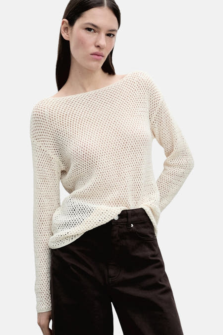 Ecru trui met ronde hals van MANGO, met open breisel textuur, gecombineerd met een bruine broek.
