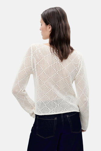 Ecru trui met ronde hals van MANGO, met open breiselstructuur, gecombineerd met donkere jeans.
