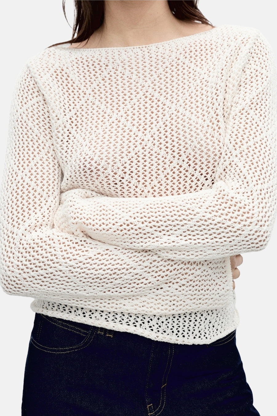 Ecru trui met ronde hals van MANGO, met open breisel en donkere jeans.
