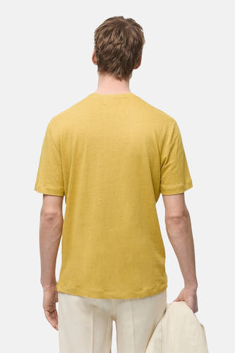T-shirt jaune à manches courtes de MANGO, vu de dos, porté avec un short et une veste.