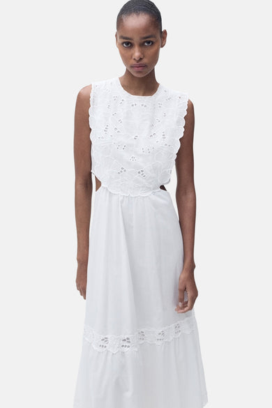 Mouwloze witte jurk van MANGO, met broderie details aan de boven- en onderkant en uitsnijdingen aan de zijkanten.