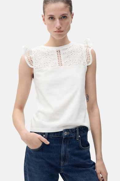T-shirt sans manches blanc de MANGO, avec des détails sur les épaules, vu de derrière, associé à des jeans bleus foncés.