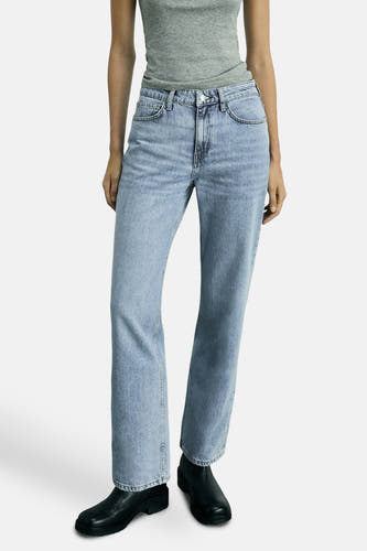 Lichtblauwe straight jeans van MANGO, gecombineerd met een grijze top en zwarte schoenen.
