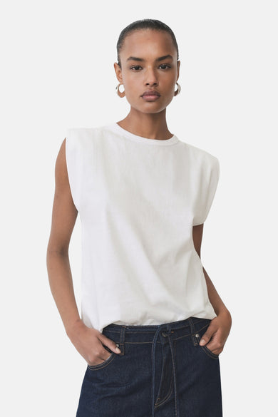 T-shirt sans manches de MANGO, porté avec des jeans foncés et des boucles d'oreilles dorées.
