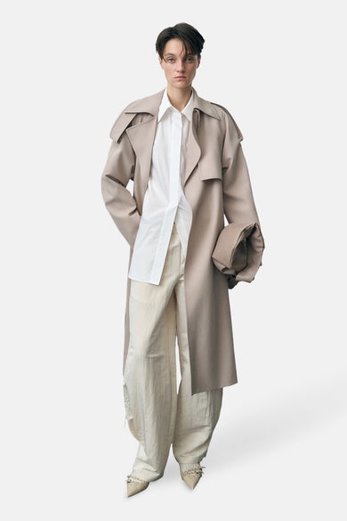 Ecru broek van MANGO, gecombineerd met een witte blouse en beige trenchcoat.