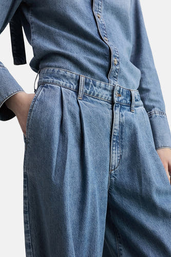 Jean décontracté de denim bleu moyen de MANGO, avec des plis et une ceinture haute.
