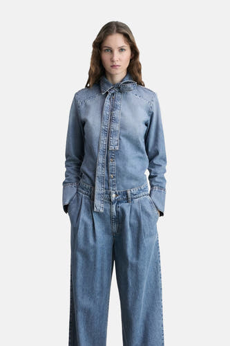 Jean en denim bleu marine large de MANGO, avec des manches longues et des bas larges.