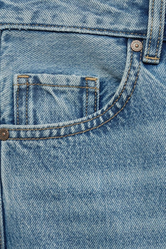 Jean droit en denim bleu clair de MANGO, avec détail de poche et points contrastés.