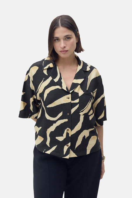 Chemise noire à manches courtes de MANGO, avec un motif beige abstrait et une poche po.