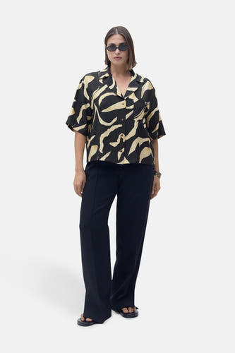 Zwart hemd met korte mouwen van MANGO, met beige, abstract patroon, gedragen met een zwarte broek en sandalen.
