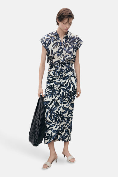 Chemise multicolore à manches courtes de MANGO, avec imprimé feuilles et associée à une jupe coordonnée.