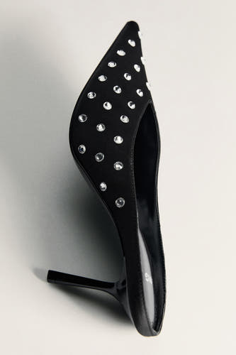 Des bottes noires de MANGO, ornées de strass argentés, dans une finition asymétrique.