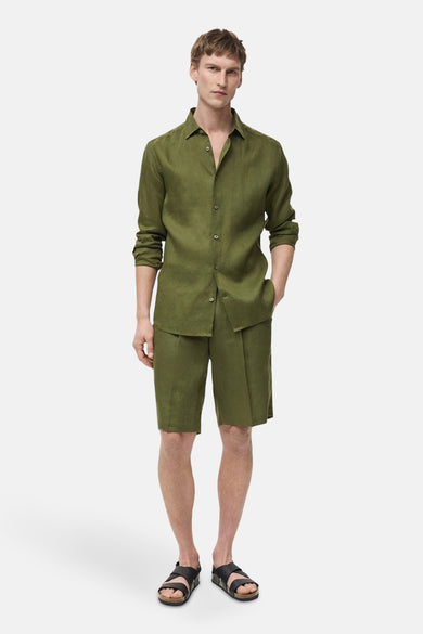Groene short van MANGO, gedragen met een bijpassend linnen overhemd en zwarte sandalen.
