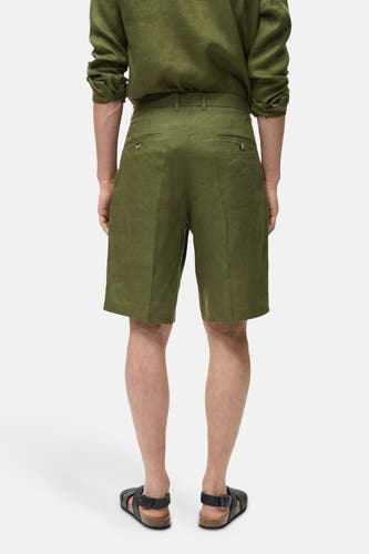 Groene short van MANGO, gezien van achteren, met zakken en een bijpassende groene linnen overhemd.
