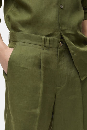 Groene short van MANGO, met tailleband en knoop, en steekzak aan de zijkant.
