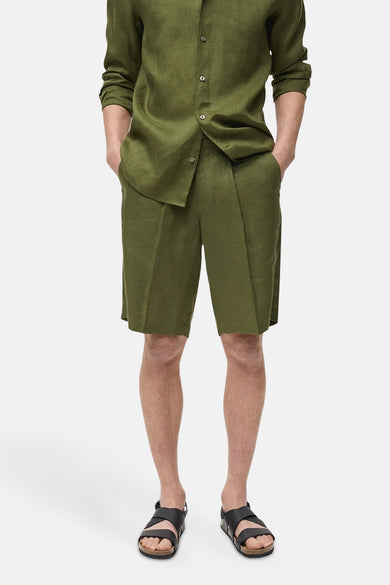 Groene short van MANGO, gedragen met een bijpassend linnen overhemd en zwarte sandalen.