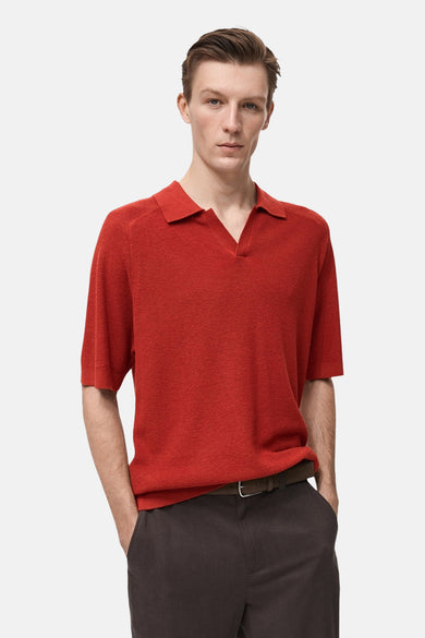 Man in rode polo met bruine broek.
