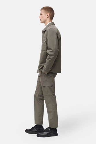 Pantalon vert de MANGO, avec des poches cargo et associé à des chaussures noires, en vue latérale.