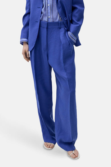 Blauwe kostuumbroek van MANGO, met wijde pijpen en gedragen met een bijpassend blauw jasje.
