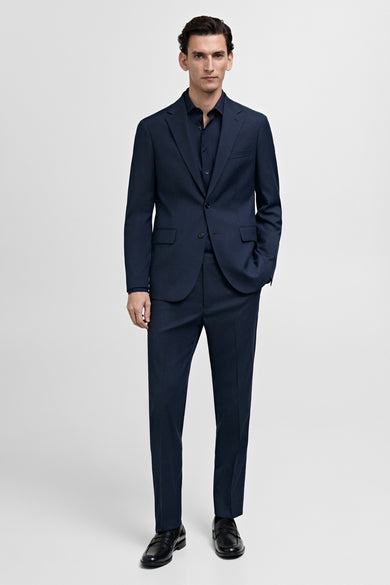 Chemise bleue à manches longues de MANGO, portée sous un costume bleu.