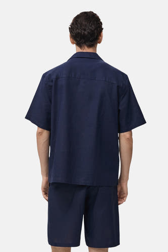 Chemise bleue à manches courtes de MANGO, vue de derrière, partie d'un ensemble avec des shorts.