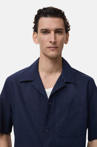 Chemise bleue à manches courtes de MANGO, avec col ouvert et poche poitrine.
