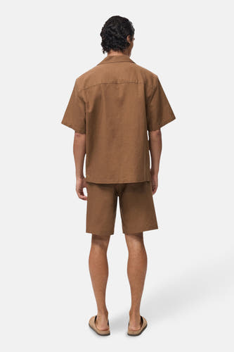 Bruin overhemd met korte mouwen van MANGO, gezien van achteren, met een bijpassende korte broek en sandalen.