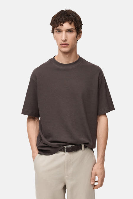Bruin T-shirt met korte mouwen van MANGO, gedragen met een beige broek en een zwarte riem.