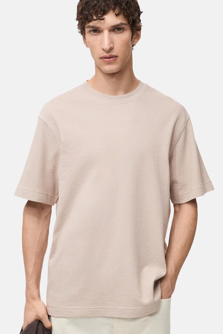 T-shirt beige à manches courtes de MANGO, avec une subtile texture et une coupe décontractée.