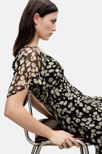 Zwarte jurk met korte mouwen van MANGO, met een bloemenprint en een vloeiende, doorschijnende stof.
