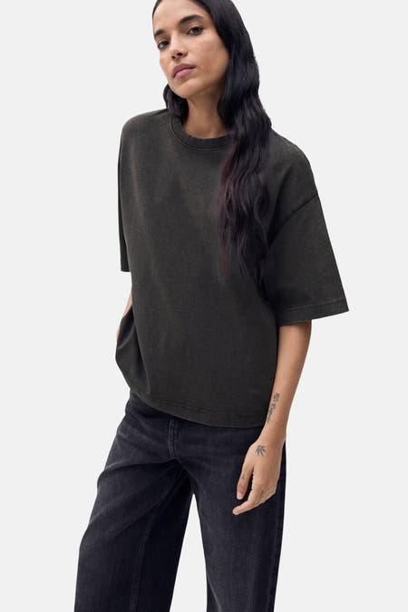 Grijs T-shirt met korte mouwen van MANGO, gedragen met een zwarte jeans.